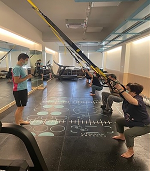 銀髮健身俱樂部教練指導長者正確使用健身設備。