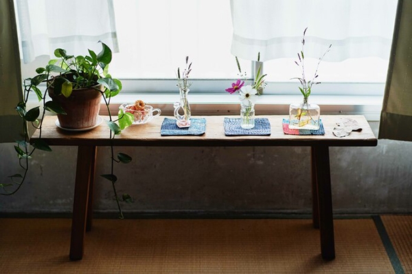 在窗邊放一張長凳、就成為一個別致的花台，小巧的瓶子裡隨意插上簡單的花草就很美。（出自ESSE）
