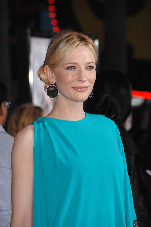 明亮湖水綠搭配黑色大耳環，給人沉穩感。（圖片來源：Shutterstock）