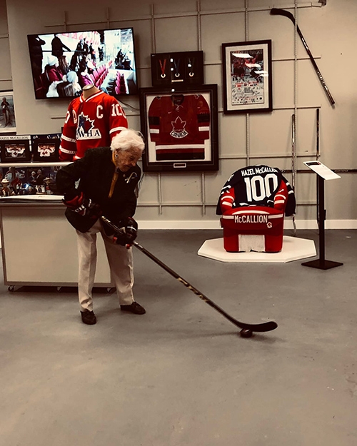 在她的100歲個人紀念特展中，麥考蓮忍不住拿起曲棍球棒比劃一番。（出自IG@ hazelmccallion100official）