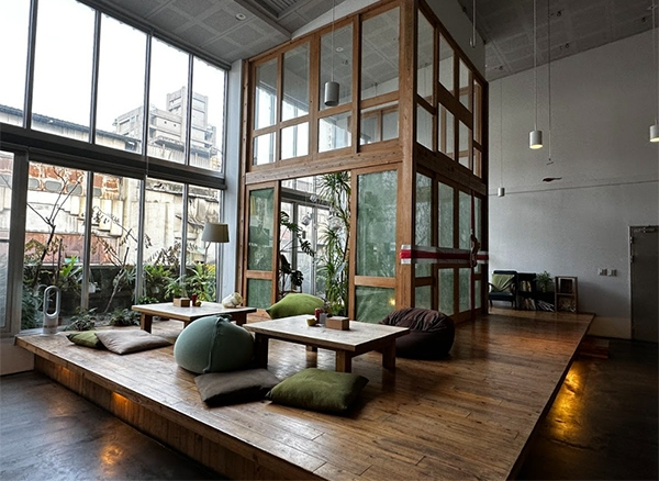 信星青年旅館交誼廳挑高兩層樓，採用休閒感十足的大量植栽。