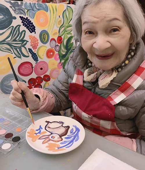 拿起畫筆，曾鳳麗表情柔和而快樂。