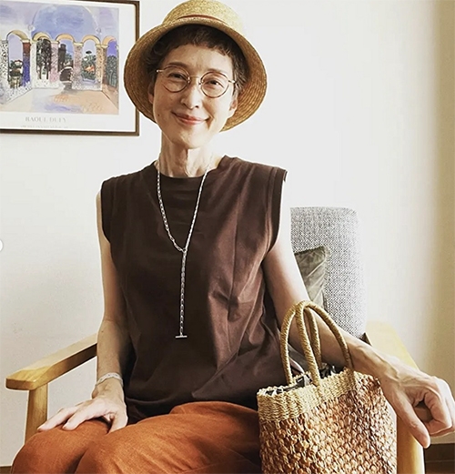 顏色一致性和長項鍊形成的視覺焦點，多少能修飾令人在意的手臂線條。帽子上的緞帶顏色與長褲顏色呼應，編織包也屬同色系。