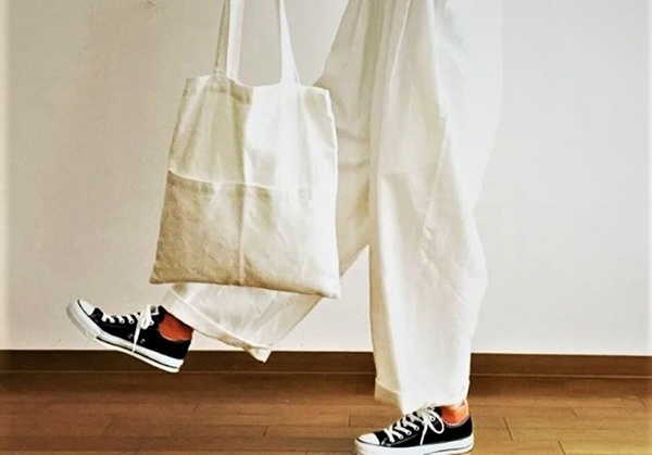 身穿白色吊帶褲、手提白色帆布袋的Mimi，卻調皮地穿了雙亮橘色襪子，而且又搭配黑低筒Converse帆布鞋。
