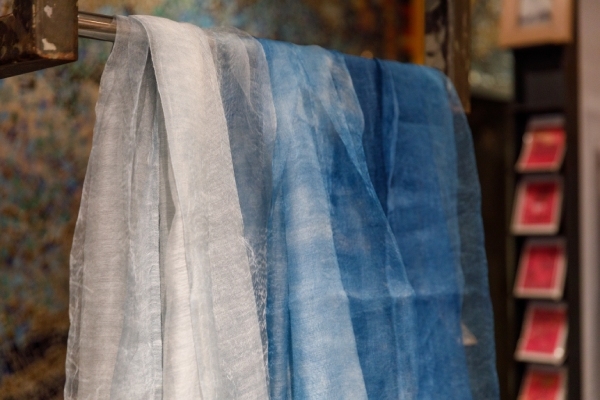 洪麗芬到三義以藍染製作的作品，圍巾色澤由淺到深，猶如天空中的雲。