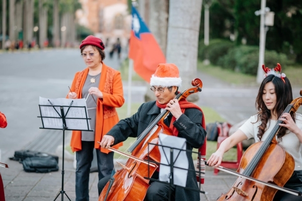 2022年底王素梅（左）、陳良基（中）與TMCO台大親子樂團在台大校園進行音樂快閃表演。此時陳良基學大提琴才3個月而已。（陳良基提供）
