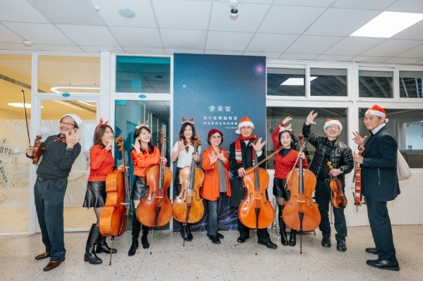 「點子王」陳良基退休前捐贈台大電機系3間實驗室，分別命名為「蟲洞」、「企業號」以及「良基練功坊」，耶誕音樂快閃與樂團在企業號門口開心合影。（陳良基提供）