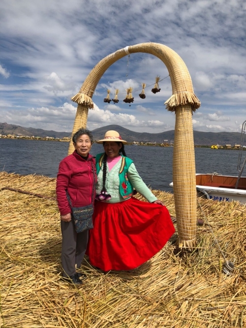 吉野登世子（左）在祕魯的的喀喀湖與當地人合影留意。