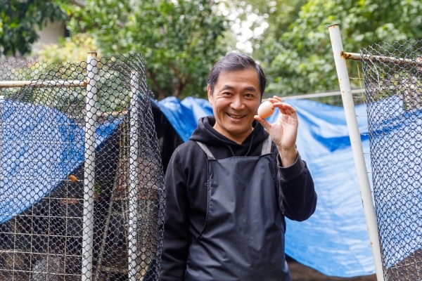 湯志偉手中拿著雞蛋，準備做一碗豬油拌飯加蛋。