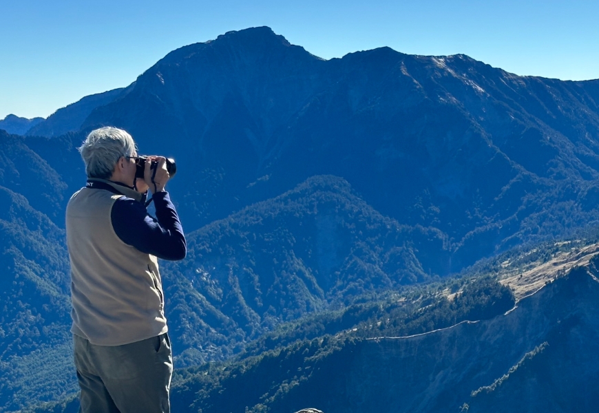 愛山與愛攝影的陳威明，在石門山上拍攝奇萊主峰。
