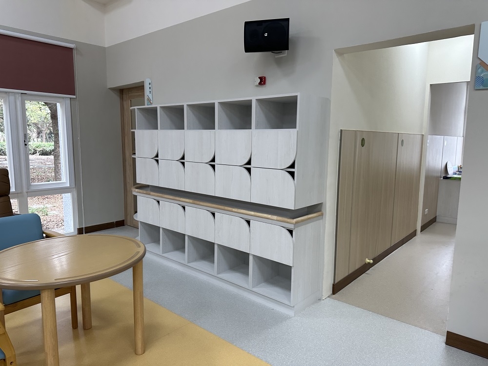 照片中白色櫃體中段懸空，使櫃體兼具扶手功能。（林嘉慧建築師事務所提供）