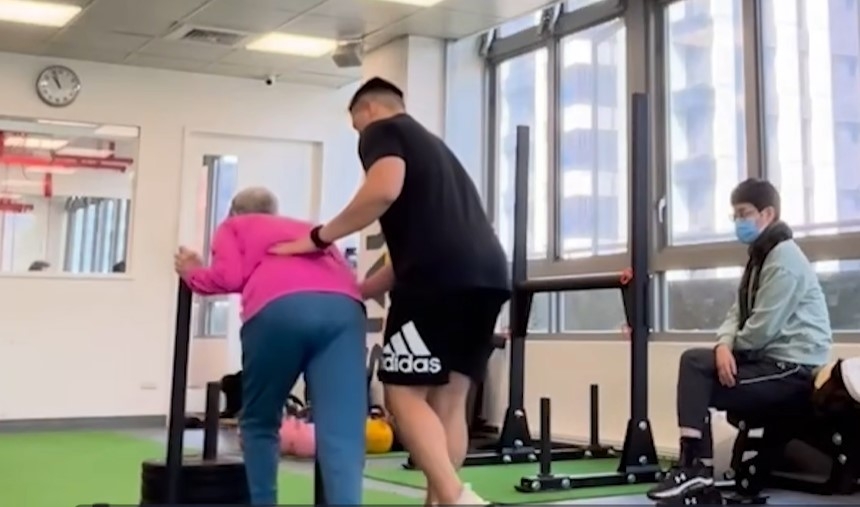 教練帶著張媽媽推雪橇，增加其心肺耐力和行走步態的協調，張曼娟（右）在旁陪伴。（圖片來源：張曼娟）