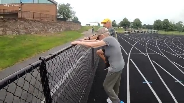 佛里曼和謝爾曼扶著運動場上的防護網左右抬腿。(出自WKYC)