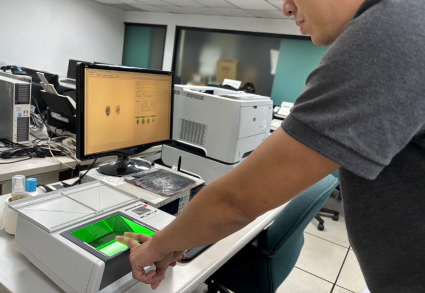 警方示範指紋捺印方式。（顏理謙攝）