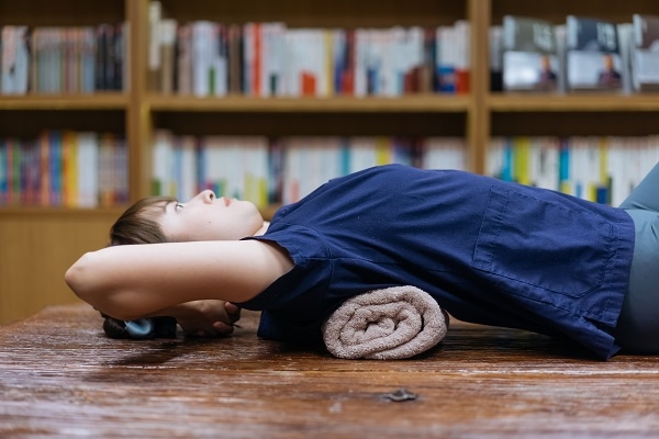 大浴巾捲起來放在胸椎往後拱起的那段，有助於打開胸椎活動度。