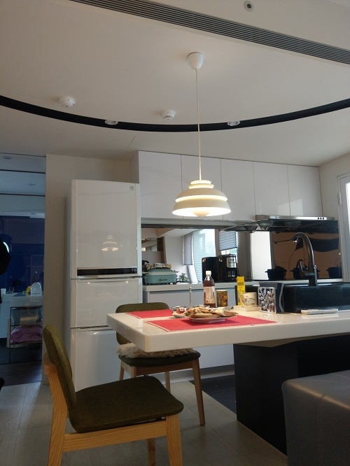 料理吧檯面向沙發處留出寬度，朋友來時，可坐在特製的沙發方形厚背上，有如吧檯椅。