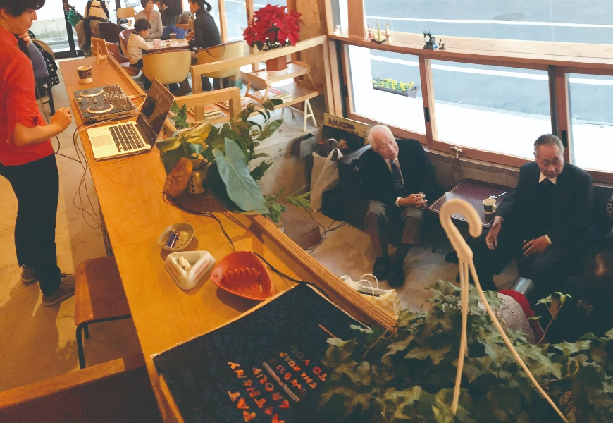 年輕DJ在播放音樂，年長者自在地坐在店內聊天，喫茶咖啡洗衣店裡常見到混齡共處的光景。