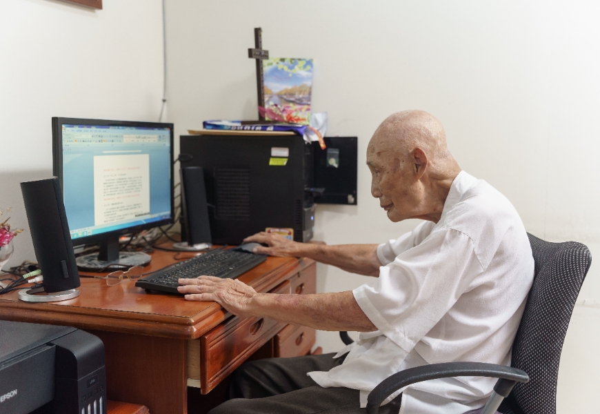 勞亦儉用電腦一字一字敲下日記。（圖片來源：影巷26號攝）