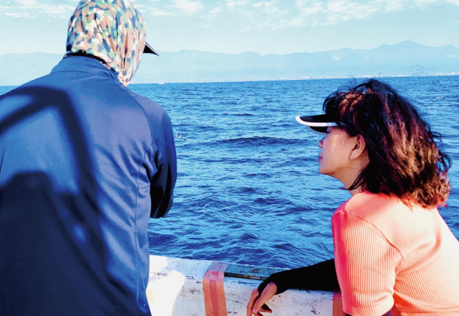 龍應台（右）與漁民一同出海，探究漁業生態問題，也了解庶民對戰爭的觀點。（時報出版提供）