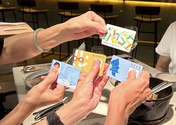 林宜平和同學聚會時，大家拿出敬老卡，討論哪個縣市設計得最好看。（林宜平提供） 