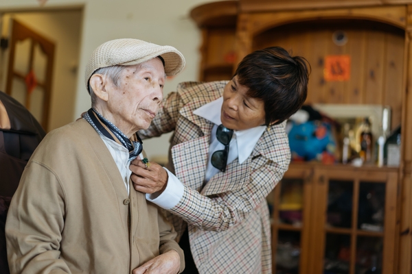 黃翠文細心幫爸爸整理衣服。