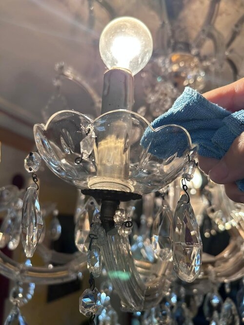 小碗似的水晶燈最容易藏灰塵，馮美莉動作輕柔，仔細擦拭。 