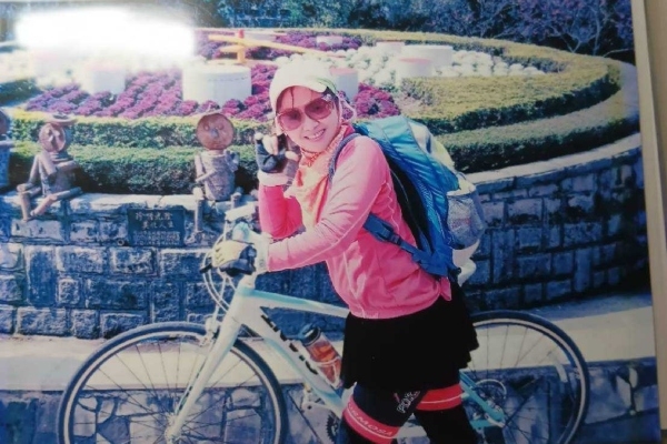 廖桂蘭昔日騎單車上陽明山，在花鐘前拍照留念。