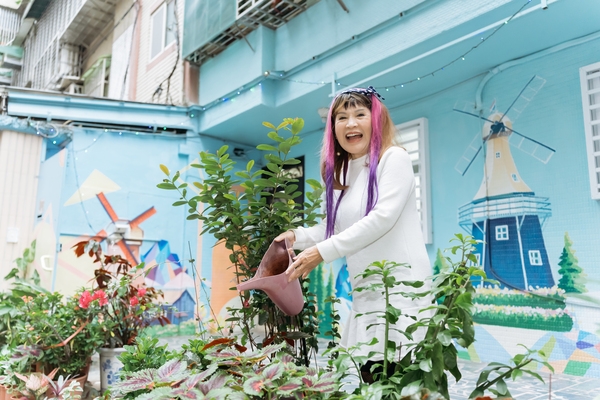 劉菊梅邊澆花邊說：「我的花比人家晚開，別人的花都開完了，我的花才開。」