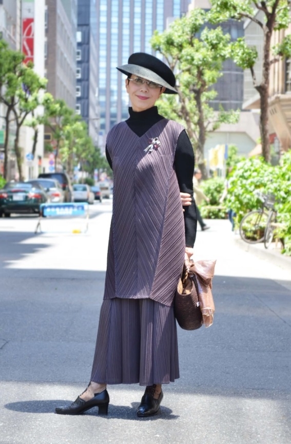 全身都以紫色、灰黑色系穿搭，營造出優雅與一絲神秘感。