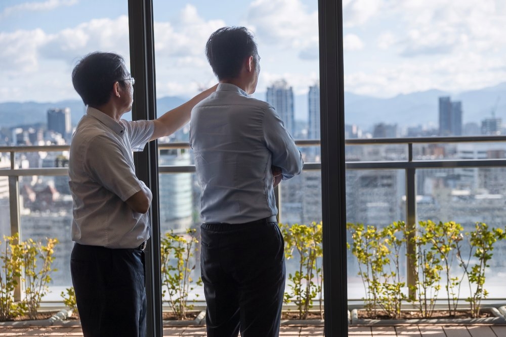 台北市都市更新處處長詹育齊（右）與科長陳俊全站在都更處大樓前，眺望台北市容。