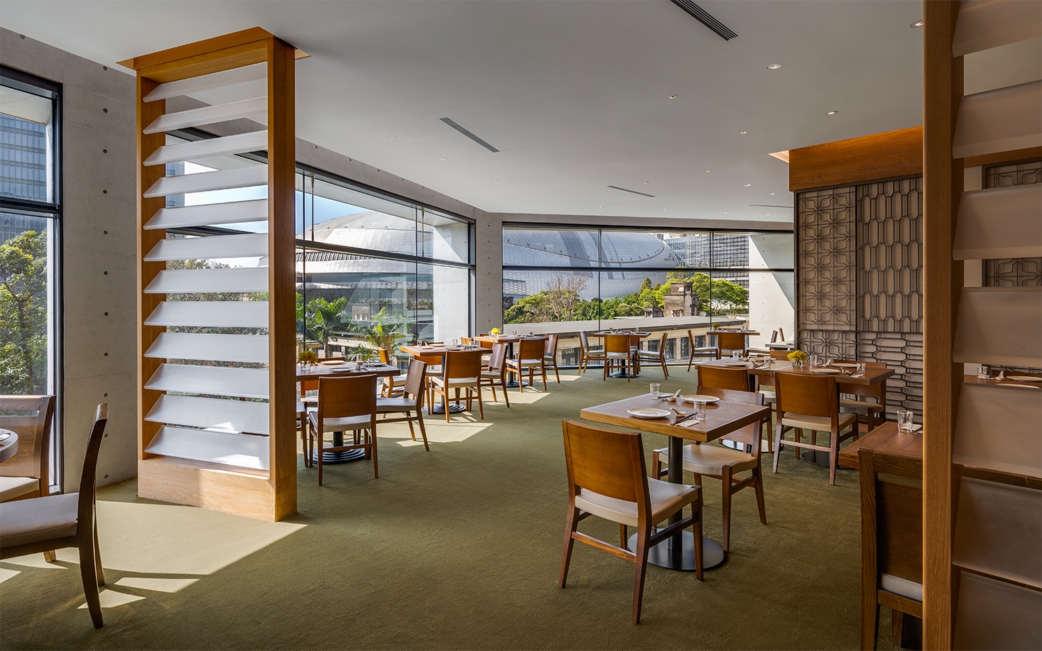 聚聚樓松菸店的用餐區域，窗外可見臺北大巨蛋，城市日常成為餐桌的一部分。（圖片來源 : 誠品行旅）