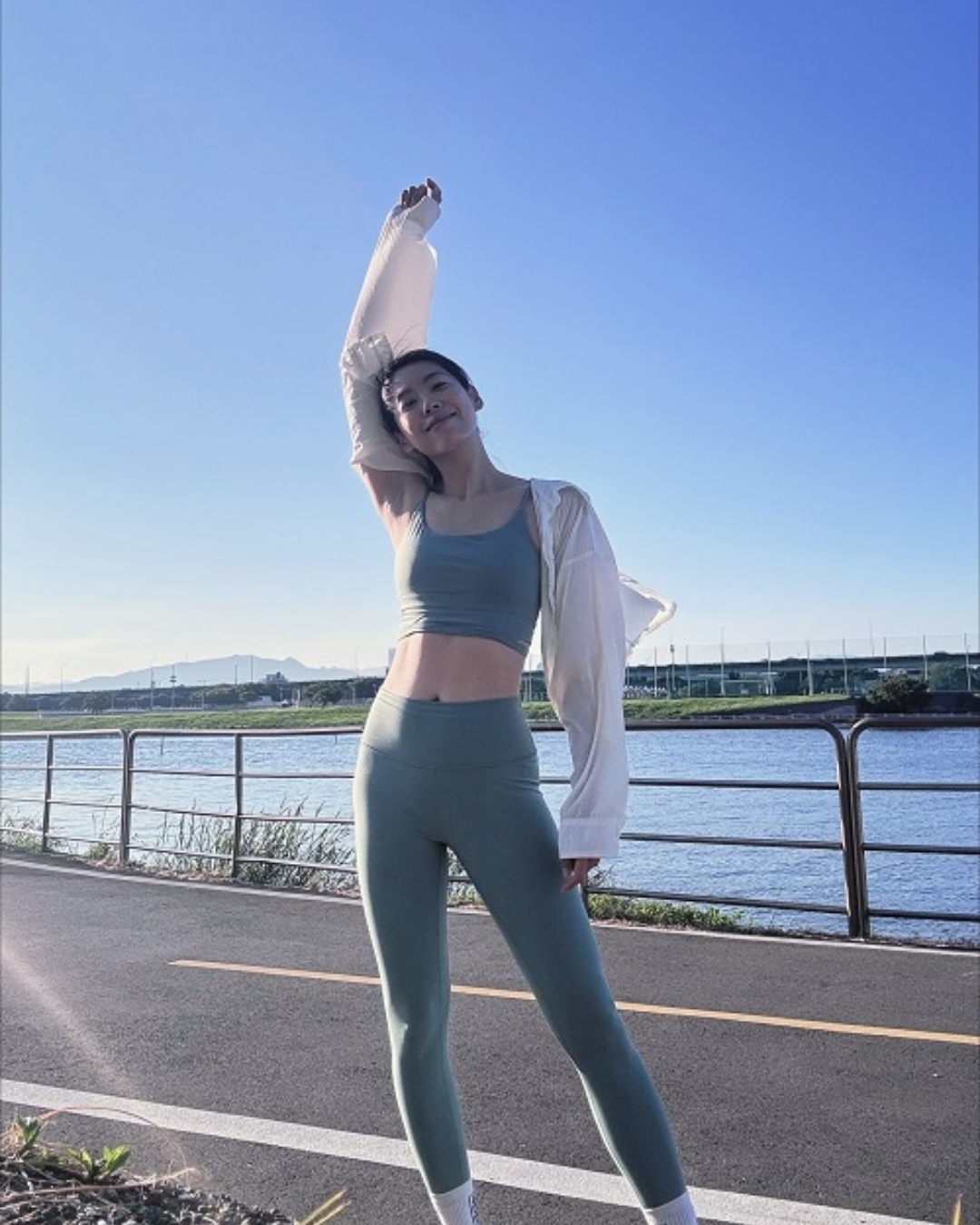 在河堤跑步時，林可彤以湖水綠配白色薄外套，比起全身同色系更加亮眼。（圖片來源：林可彤Hopelinfansclub）