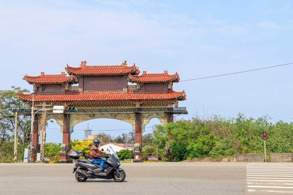看到馬路對面的牌樓，意味著崎頂濱海遊憩園區不遠了。（圖片來源：葉琳喬攝） 