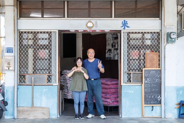 春秧糧食米店經營者吳氏夫妻俏皮地對著鏡頭比Ya和愛心。（圖片來源：葉琳喬攝）