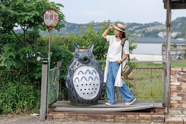 和龍貓拍照別只看鏡頭，一手扶帽簷，一手插口袋，視線往旁邊看，假裝在等公車，畫面更生動。（圖片來源：葉琳喬攝）