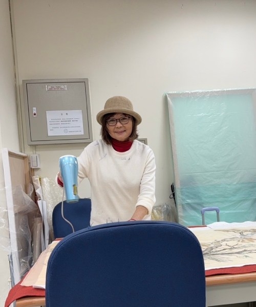 打扮優雅的張金英，正在教室裡創作。（圖片來源：張金英） 