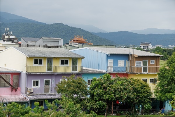 從冬山車站月台可遠眺彩虹屋，景致媲美基隆正濱漁港。這處40年老宅於2020年由冬山鄉公所彩繪上漆，成為在地亮點。（圖片來源：葉琳喬攝）