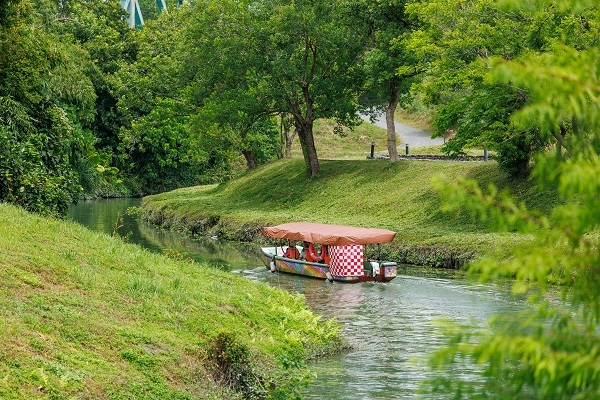 小船行駛在冬山河舊河道上，兩岸的綠色自然風光更添旅遊魅力。（圖片來源：葉琳喬攝） 